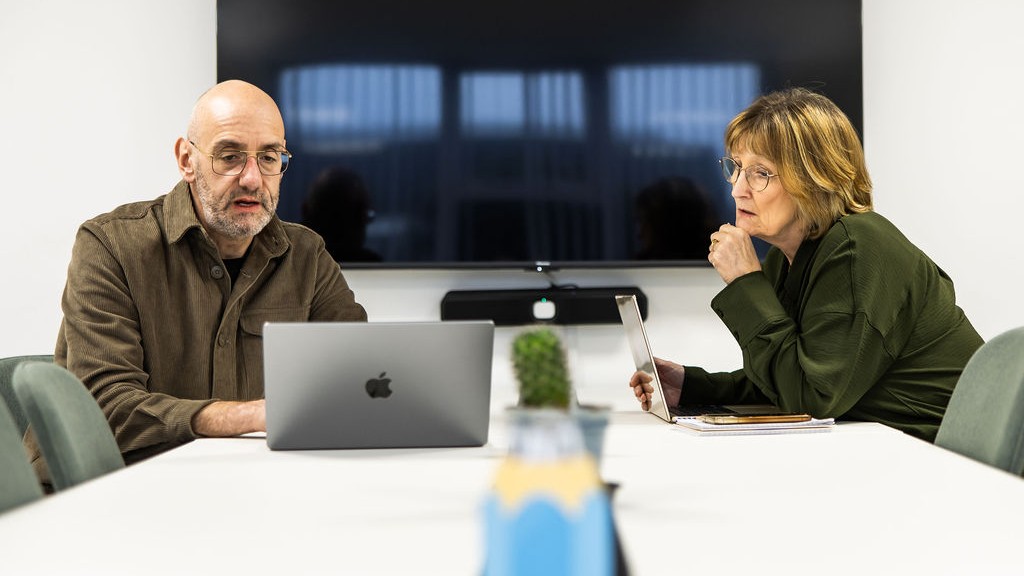 Two Schudio colleagues working through school website content together on a laptop