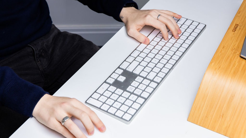 Close up of hands at a keyboard updating school website policy pages
