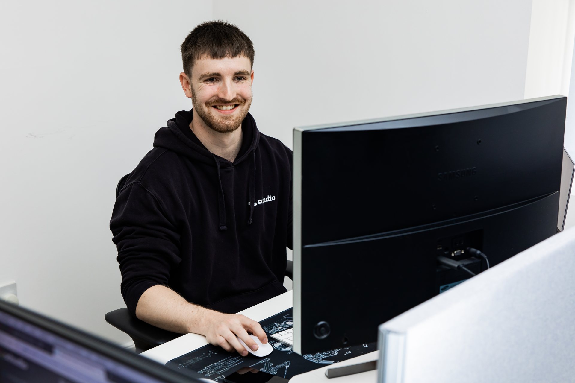 A Schudio team member reviewing content on screen at his desk